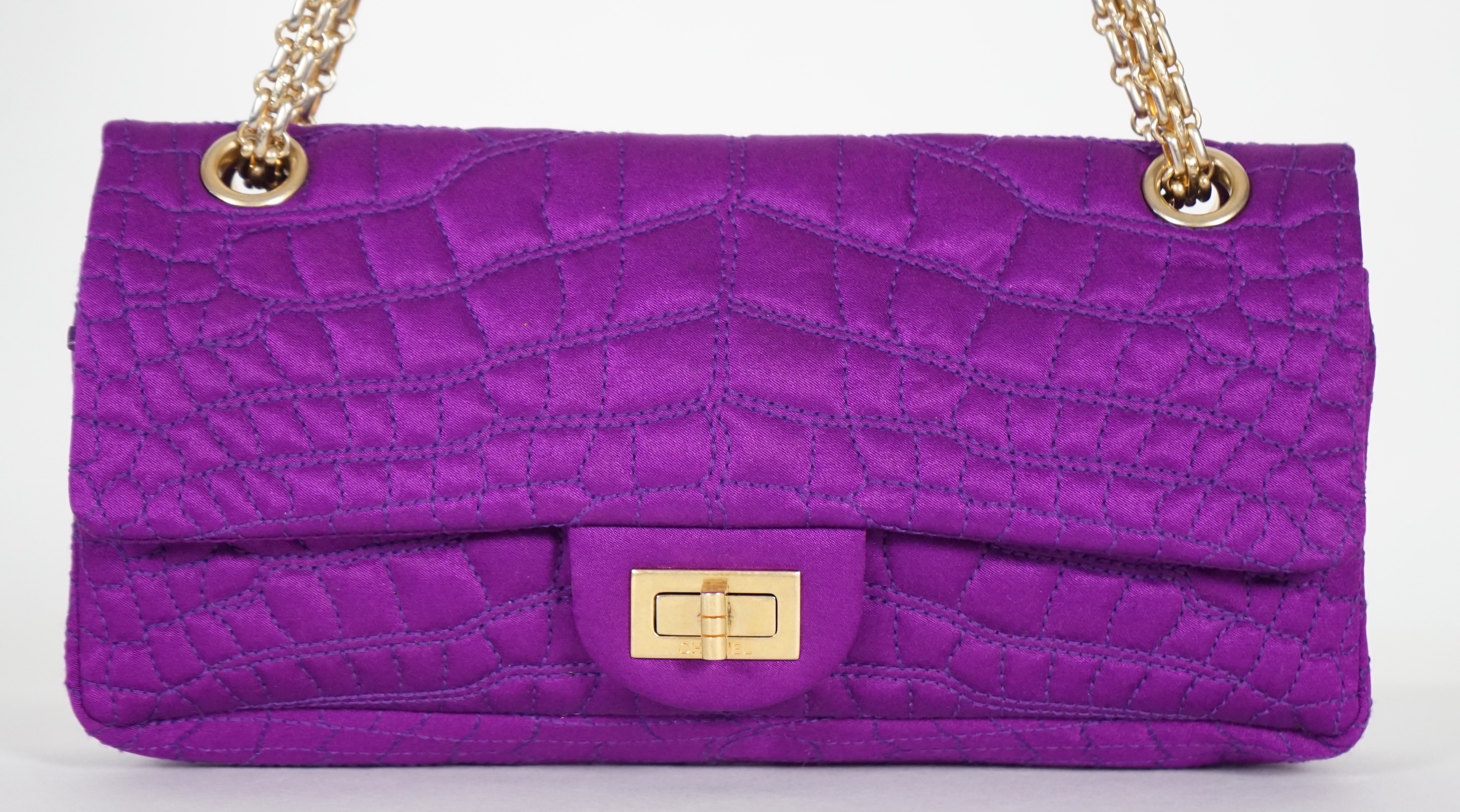 A Chanel medium-sized 2-55 bag in purple silk satin stitched with a quilted crocodile pattern, width 24cm, height 15cm, depth 6cm Single handle 112cm, Double handles 65cm